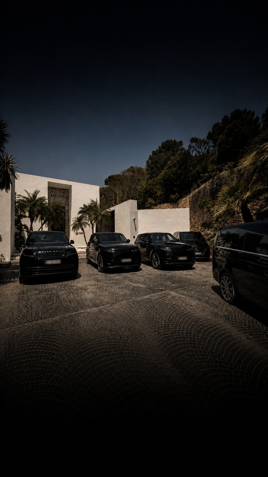 Fleet of black vehicles staged at a private residence